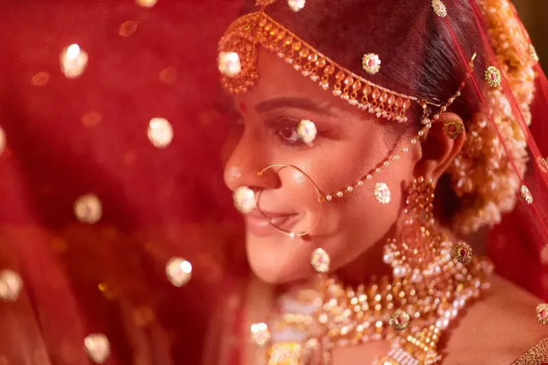 Sikh bride wearing equisite dupatta and traditional gold jewellery.