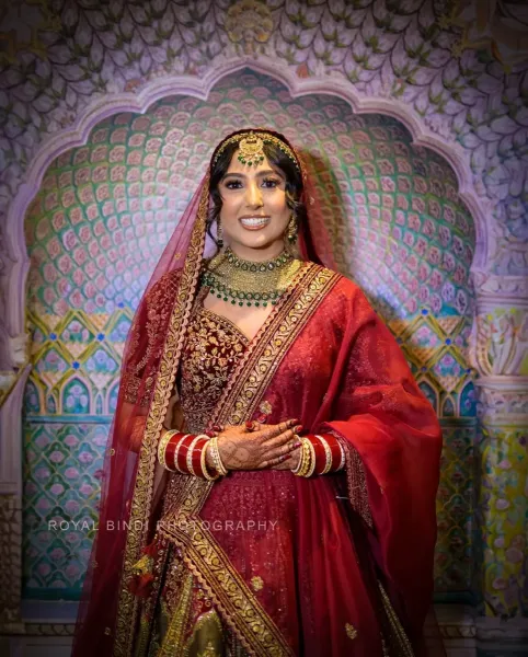 Sikh bridal smiling, wearing traditional wedding attire.