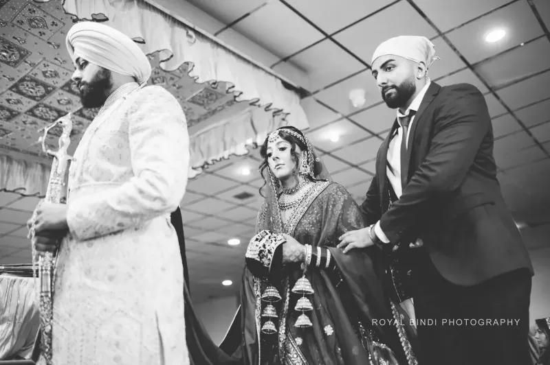 Sikh couple performing their wedding traditions in a Gurdwara.