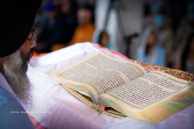 A person reading from a holy book in the Gurdwara.