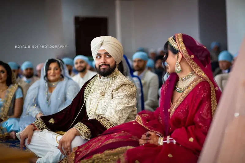 Couple sitting in Gurdwara, Groom looking at the bride.