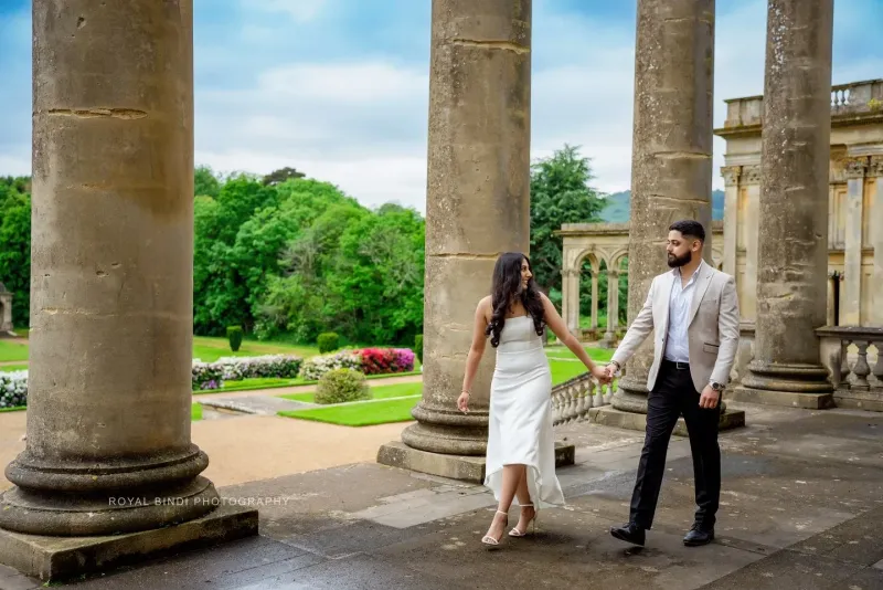 Couple pre-wedding photoshoot at a historic location and holding hands of each other.