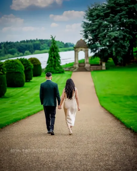 Couple holding hands in a garden.