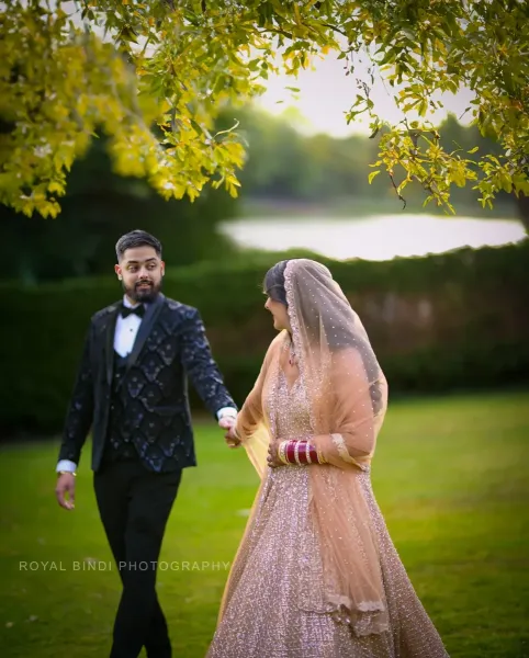 Couple\'s candid moment looking at each other holding the hands in a garden.