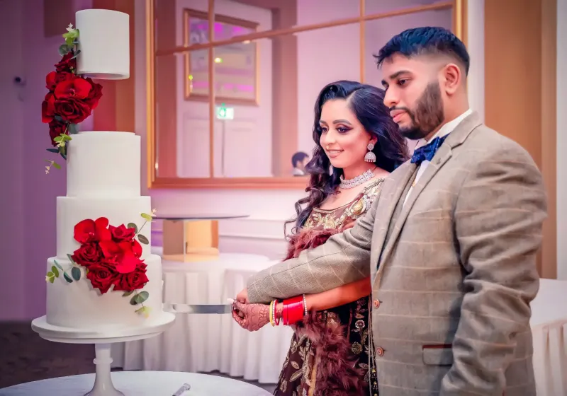 Couple cutting a big cake at their reception.