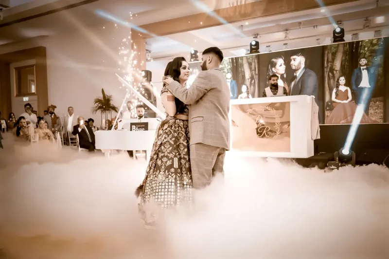 Sikh couple dancing at the floor with smoke arround them.