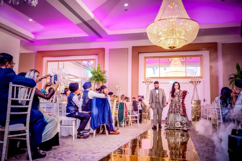 Couple enterance in the wedding reception with guests looking at them.