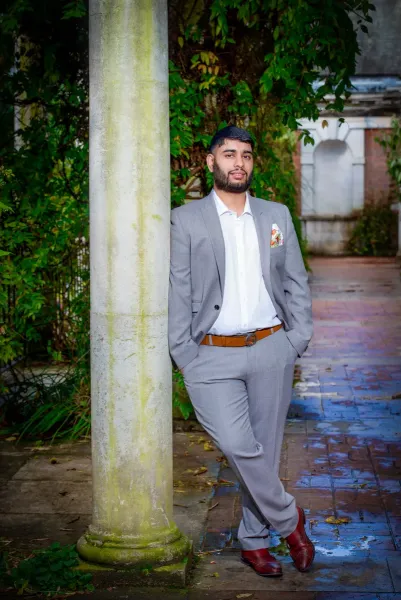 Grooms pose for the pre-wedding photography standing by a pillar.