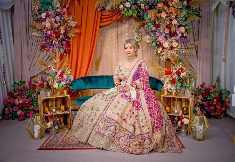 Sikh wedding bridal sitting on sofa with beautiful flower background.