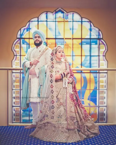 Ramita and Amrits standing besides a rail in the Gurdwara.