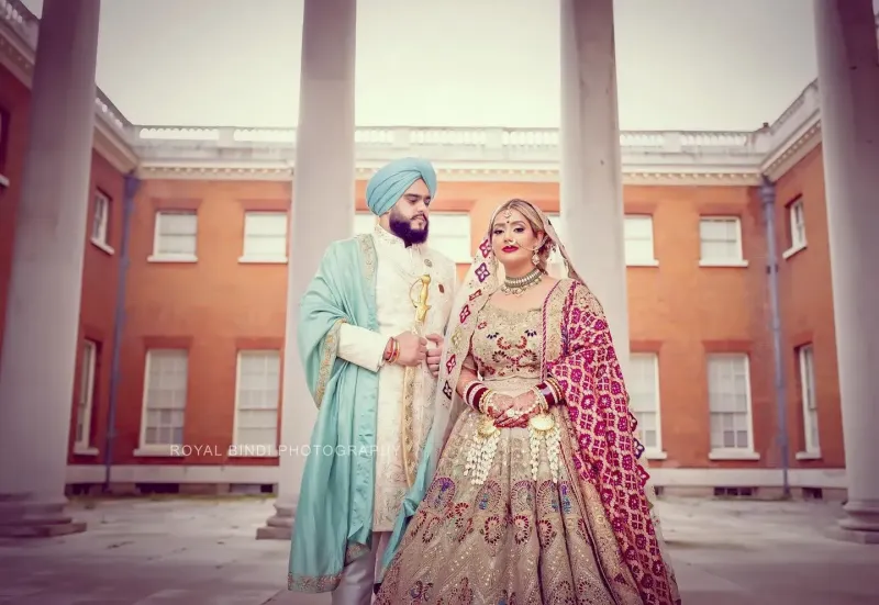 Sikh couple standing in front of Pillars.