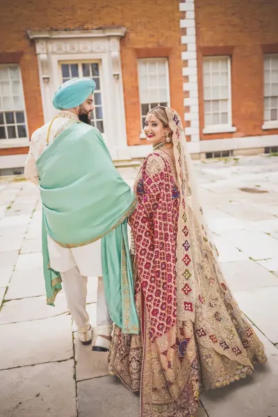 Sikh Bride Smiling While Walking with Groom at Elegant Venue