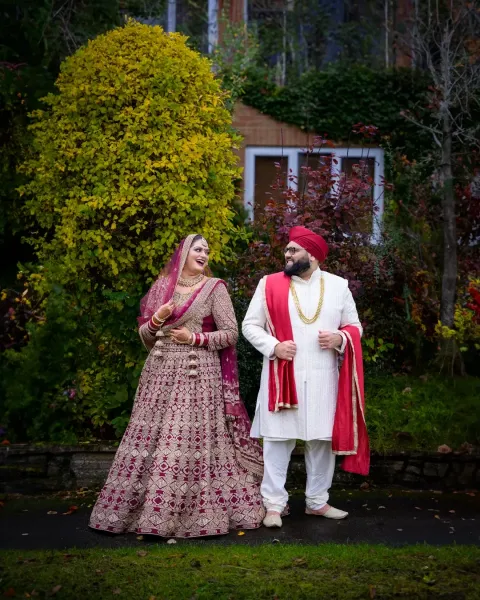 Smiling Sikh Couple in Traditional Wedding Attire Outdoors