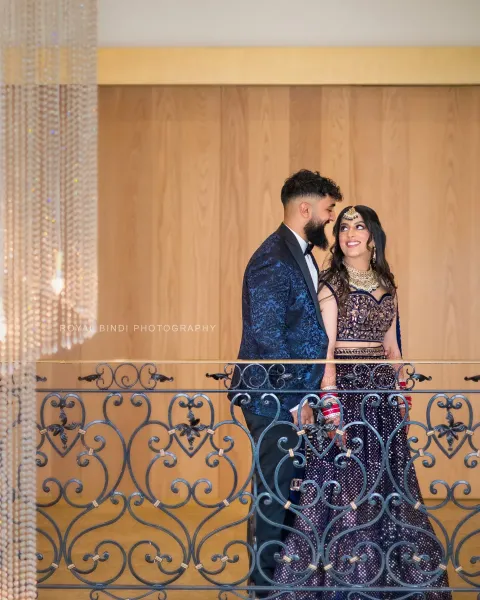 Stylish Sikh Couple Posing by Ornate Balcony at Wedding Reception