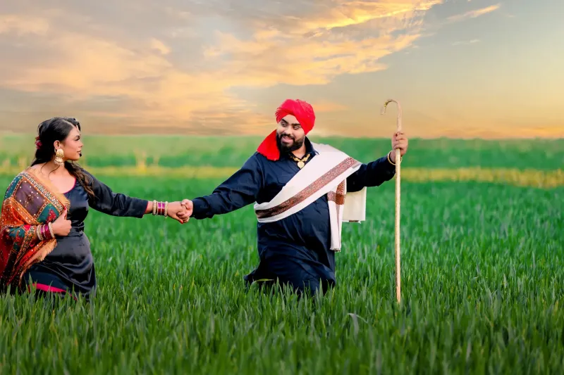 Traditional Punjabi Couple Holding Hands in a Field at Sunset