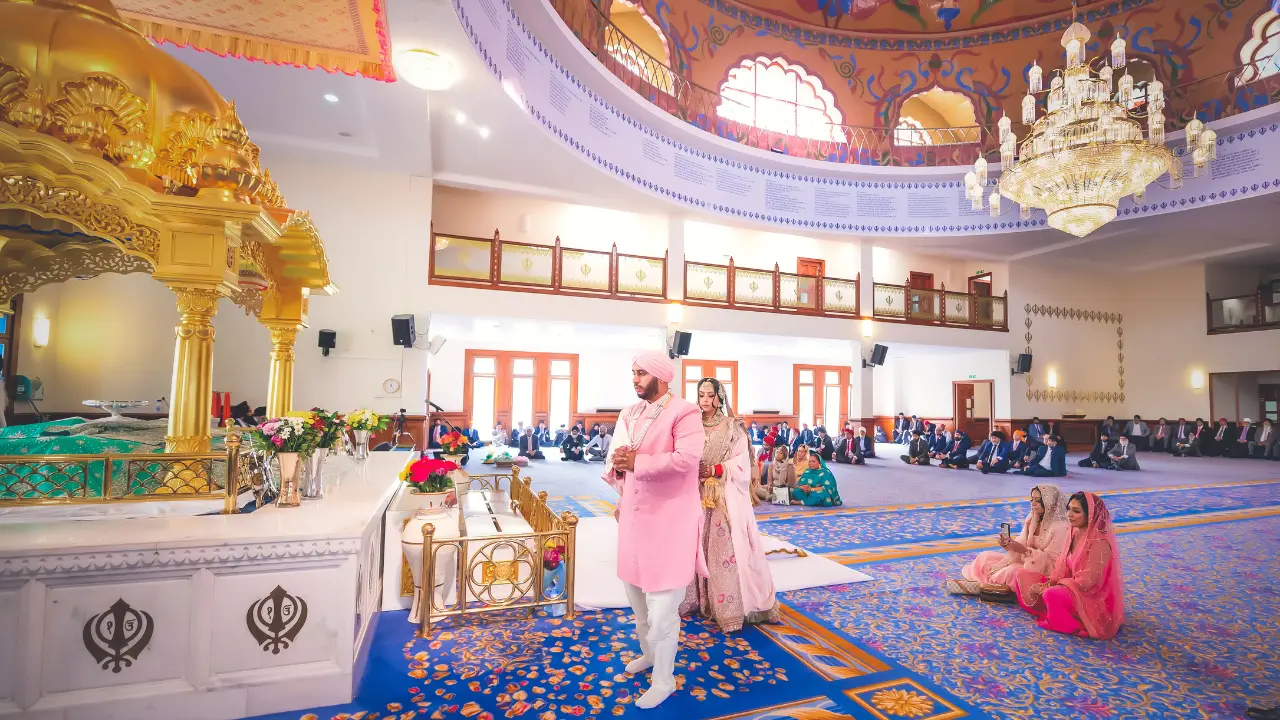 Bride and groom during an Anand Karaj Sikh wedding ceremony at the Sri Guru Nanak Darbar Gurdwara in Gravesend, with vibrant decor and traditional rituals