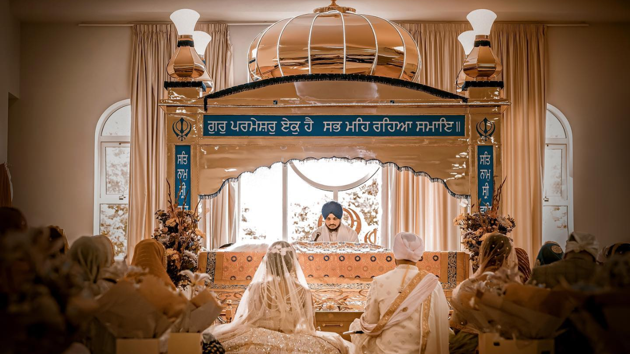 A Couple Standing Together in a Serene Gurdwara Surrounded By Its Peaceful Atmosphere