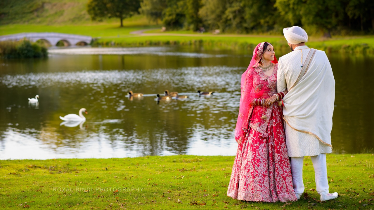 A couple standing in a beautiful garden, surrounded by lush greenery and scenic views.