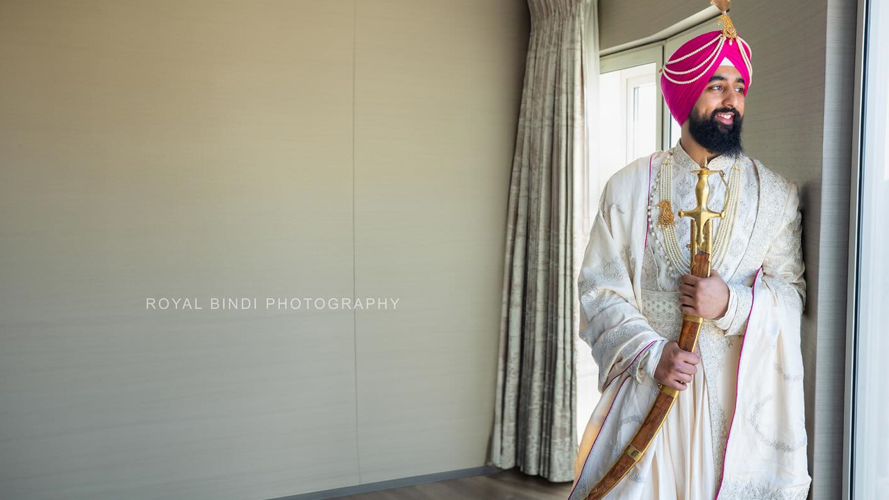 Groom in traditional Sikh outfit holding sword