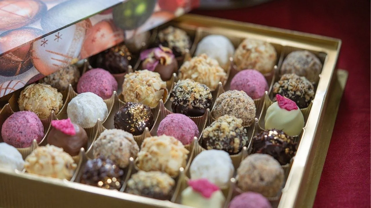 Box of assorted chocolate truffles with various fillings and coatings.