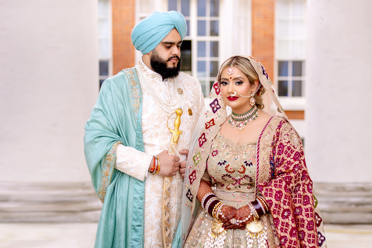 Ramita and Amrit standing together during their Sikh wedding.