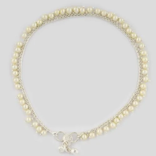 A delicate anklet adorned with small pearls and silver details