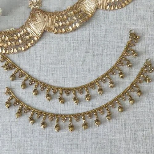 Two gold anklets with dangling bead details.