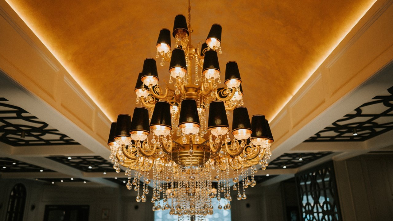 A large, ornate chandelier with crystal accents hangs from a high ceiling.