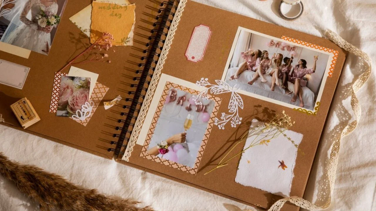 An open scrapbook page filled with wedding photos, decorative papers, stickers, and other embellishments.