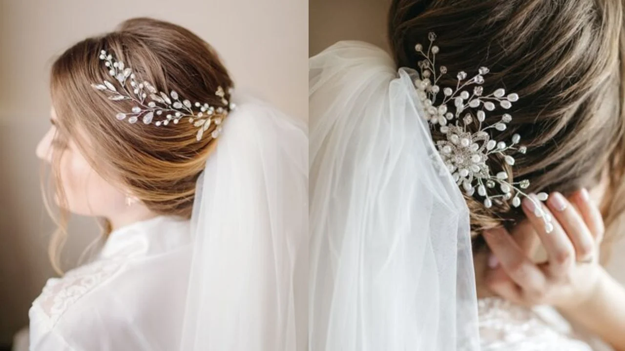 A bride wearing a veil with an ornate hair accessory featuring crystals and pearls, styled with her hair in a low updo.