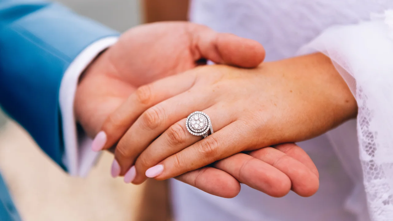 A close-up of a diamond engagement ring on a woman's finger.