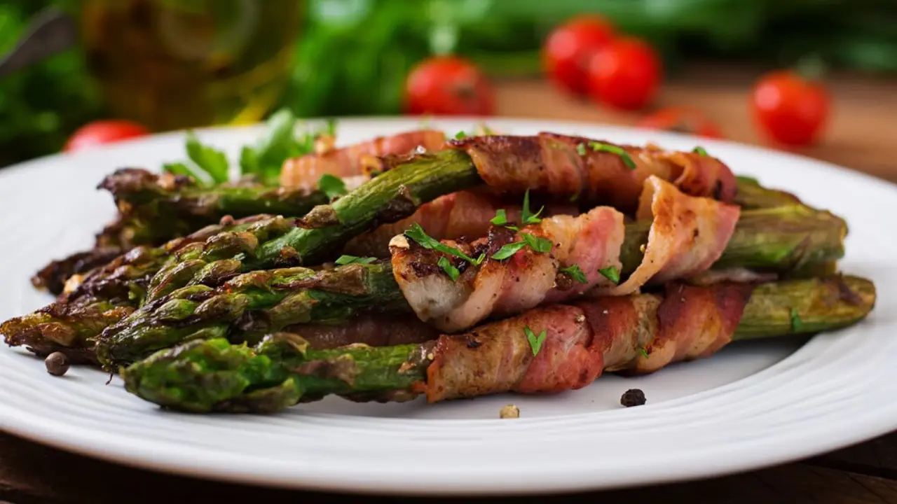 A plate of asparagus spears wrapped in crispy bacon, garnished with fresh parsley and peppercorns.