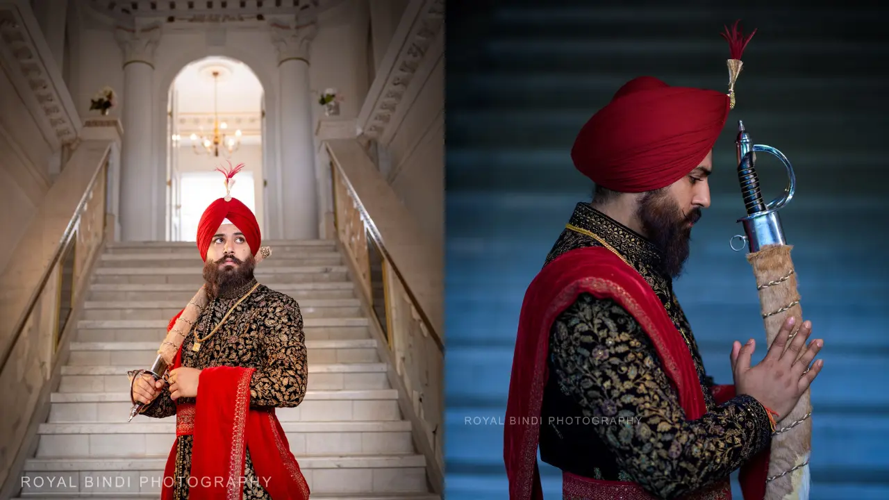 Sikh Groom dressed in traditional attire, showcasing a vibrant feather Kalgi atop a richly colored turban, stands confidently against a backdrop of intricate patterns and luxurious fabrics, embodying a majestic and sophisticated presence.