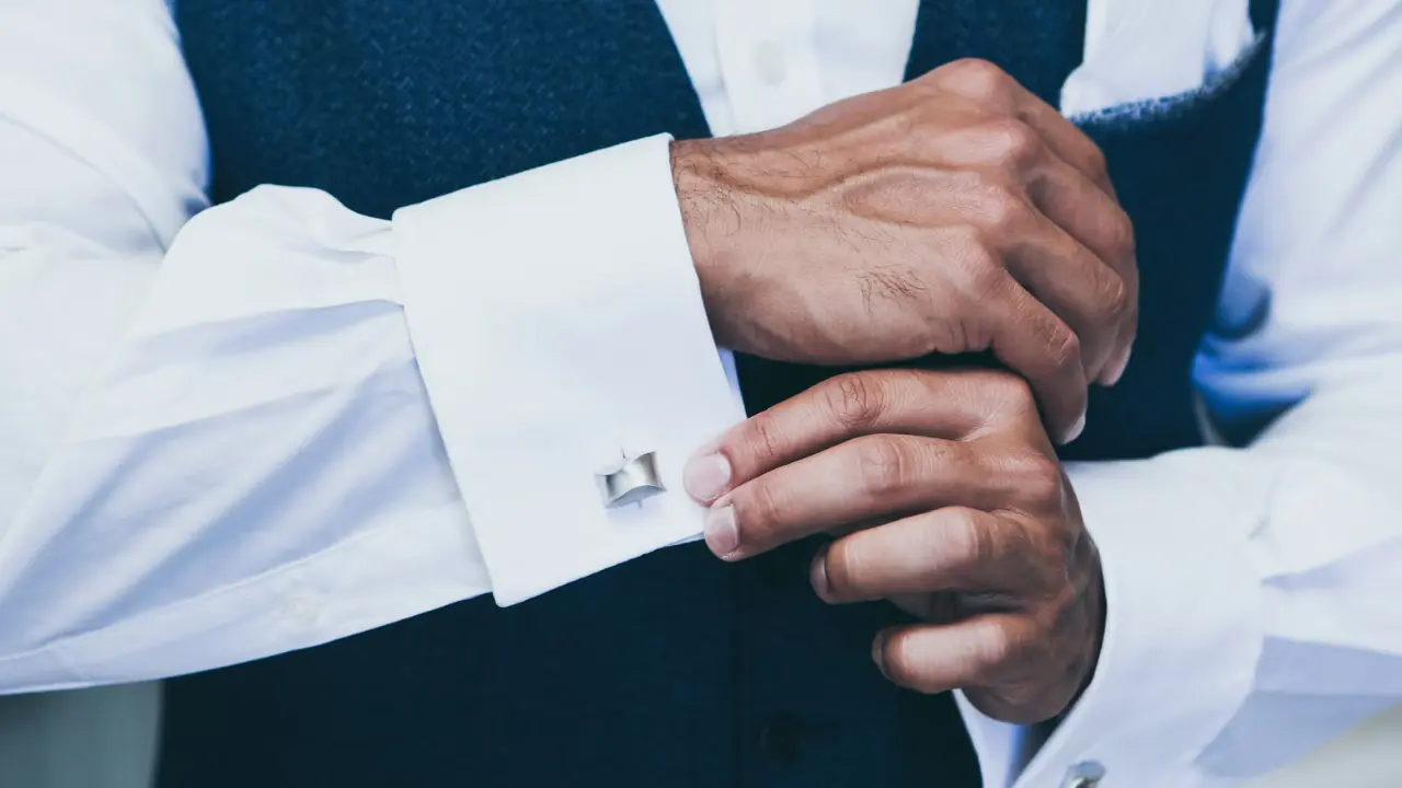 A pair of black oval cufflinks on a white surface.