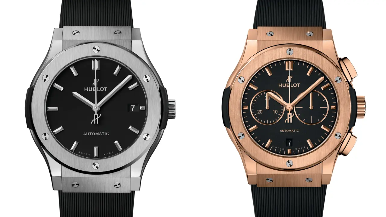 Two Hublot Classic Fusion watches side by side. The watch on the left has a titanium case with a black dial and a black rubber strap. The watch on the right has a King Gold case with a black dial and a black rubber strap. Both watches have a date window at 3 o'clock and automatic movements.