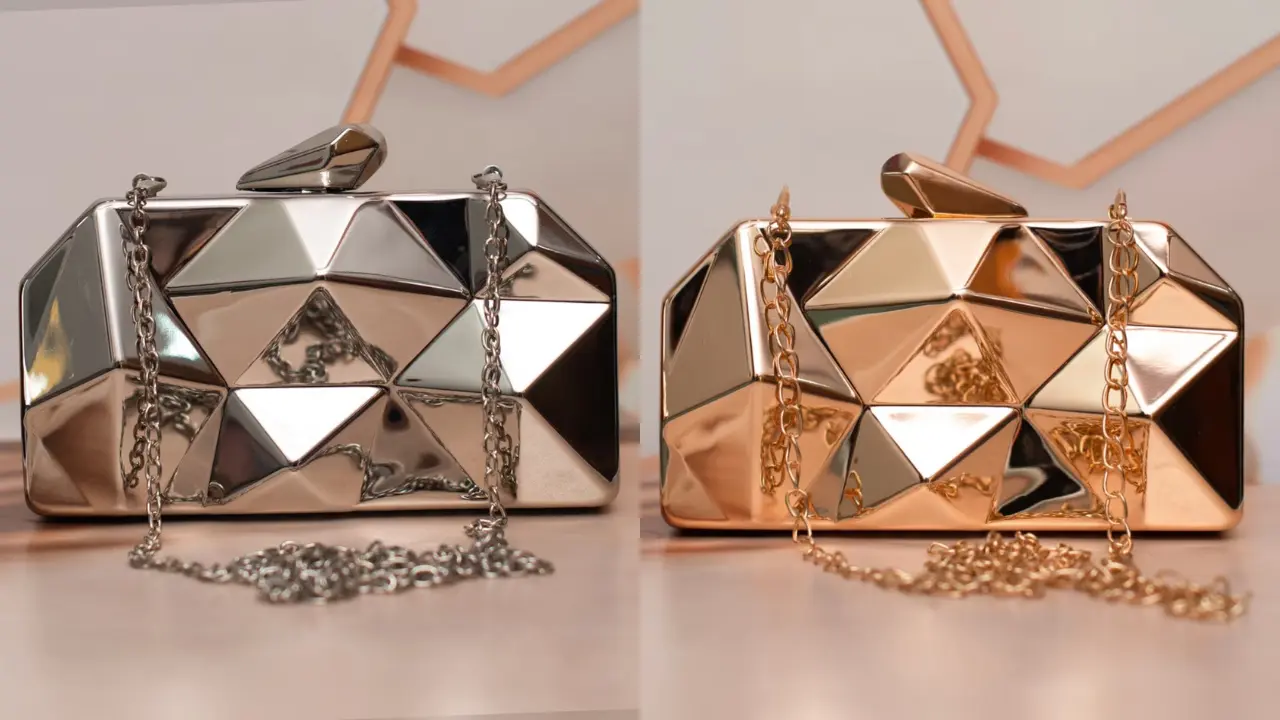 Two metallic clutches with a geometric design, one in silver and one in gold, displayed on a table.