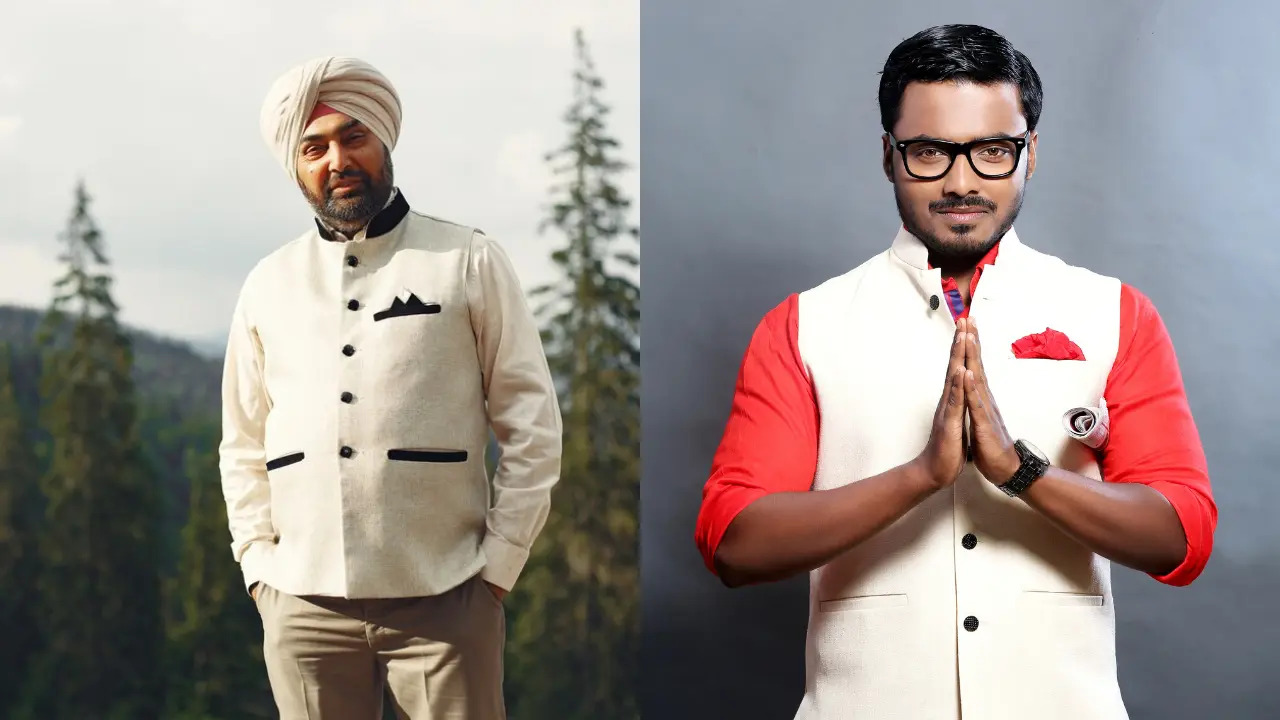 Two men standing side by side, wearing traditional attire. The man on the left is wearing a white turban, a white kurta, and a white waistcoat. The man on the right is wearing a white waistcoat, a red shirt, and black glasses. The man on the right is holding his hands in a prayer position. The image is shot in a studio with a gray background.