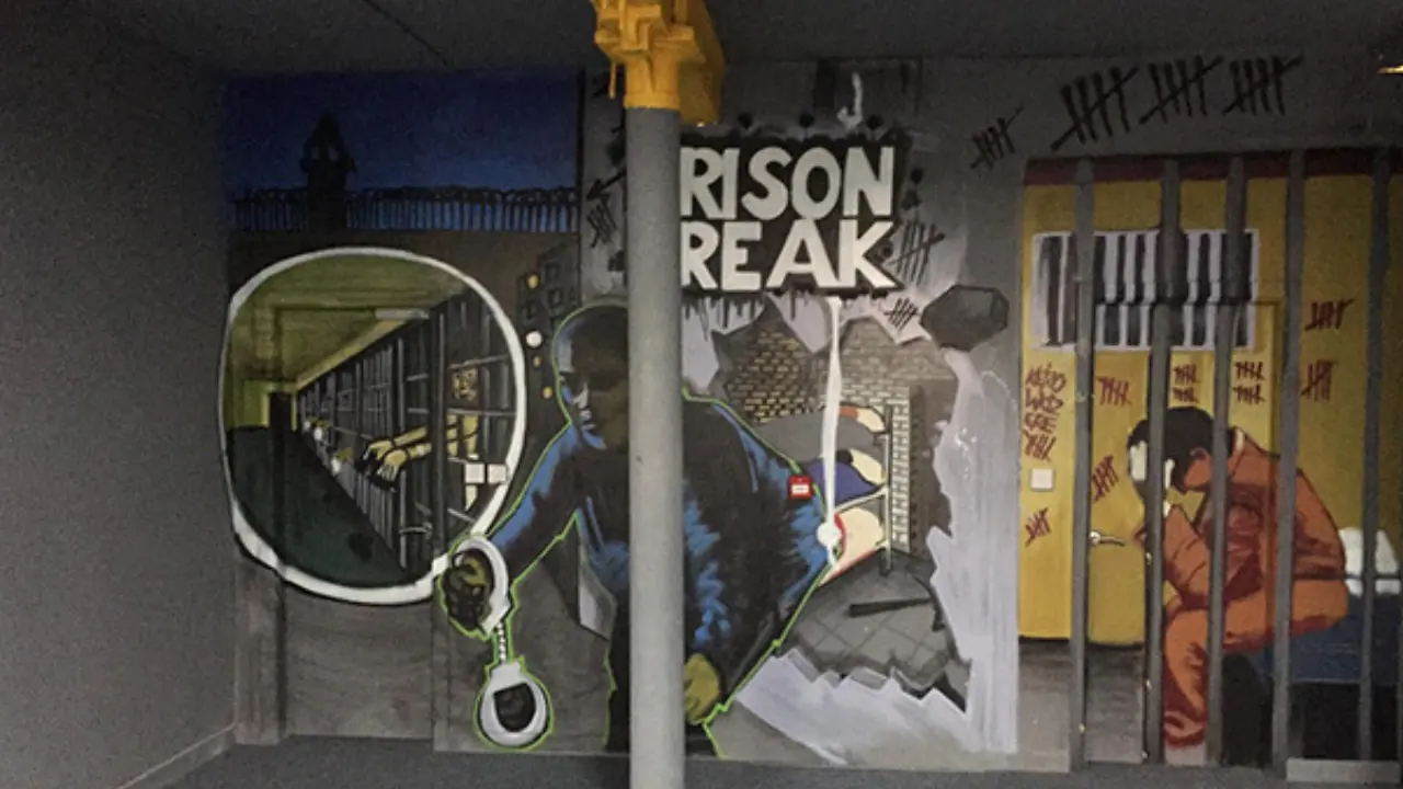 A mural depicting a prison break scene, leading into an escape room.