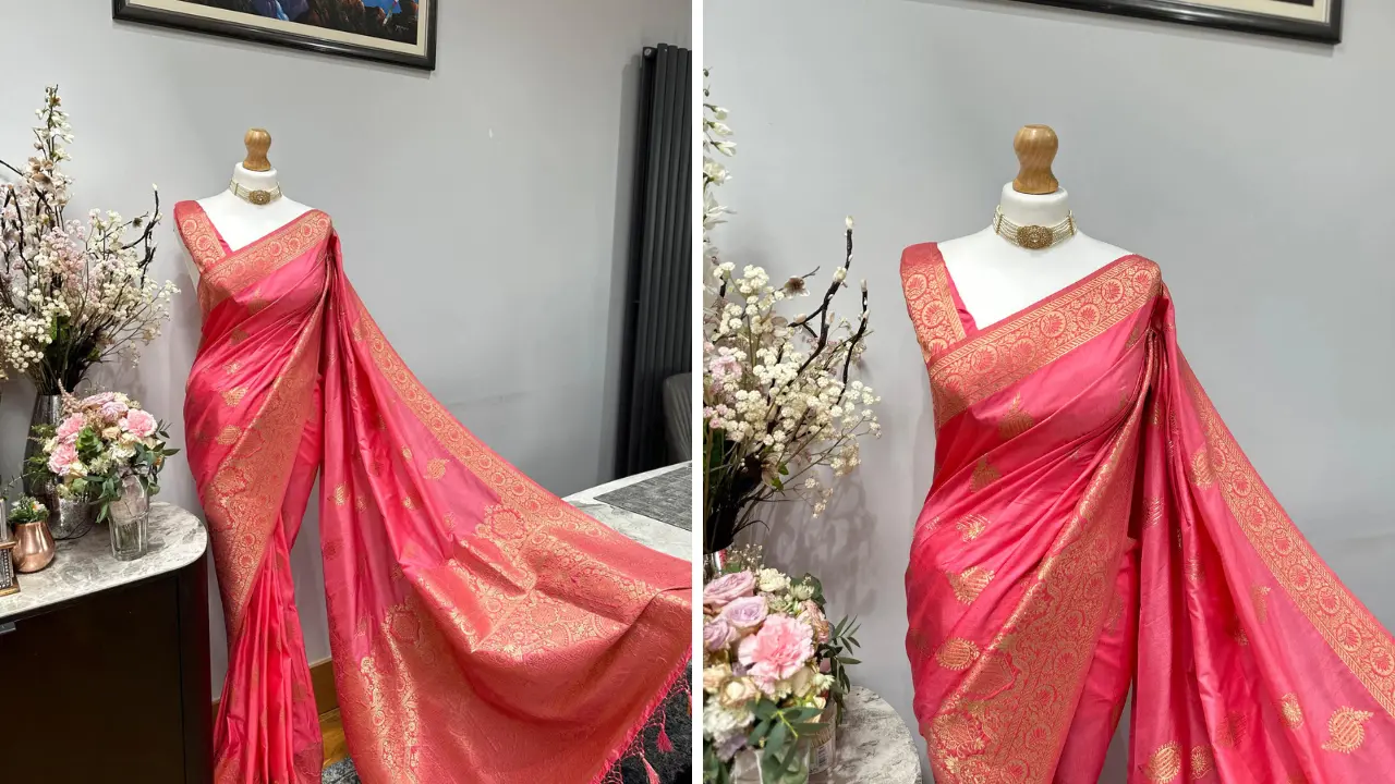 A beautiful pink Banarasi silk saree with intricate gold zari woven designs. The saree is draped on a mannequin and displayed against a white background.