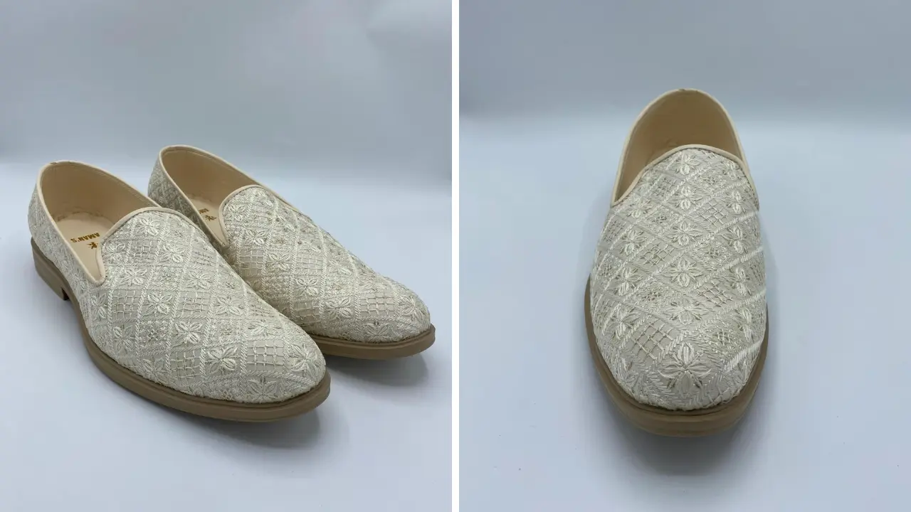 A pair of cream-colored embroidered loafers with a slip-on design.