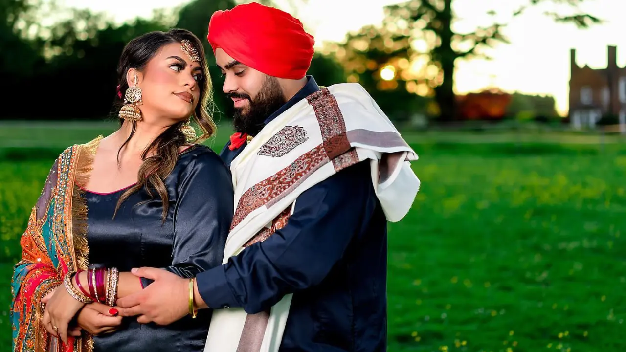 A Sikh bride and groom smiling on their wedding day, adorned in traditional attire with elegant jewellery, showcasing the cultural significance of Sikh wedding rituals.