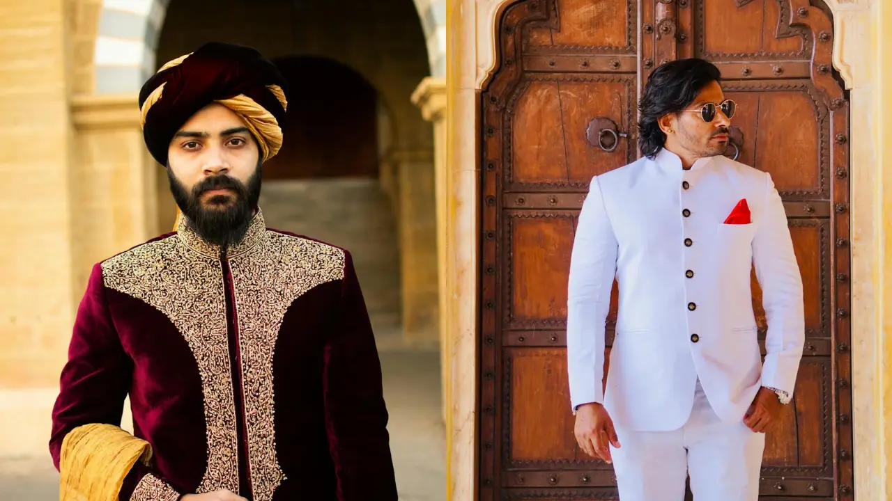 Two men in traditional Indian attire standing in front of a wooden door. The man on the left is wearing a burgundy jacket with gold embroidery, and a yellow turban. The man on the right is wearing a white suit with a red handkerchief in his pocket. They are both smiling.