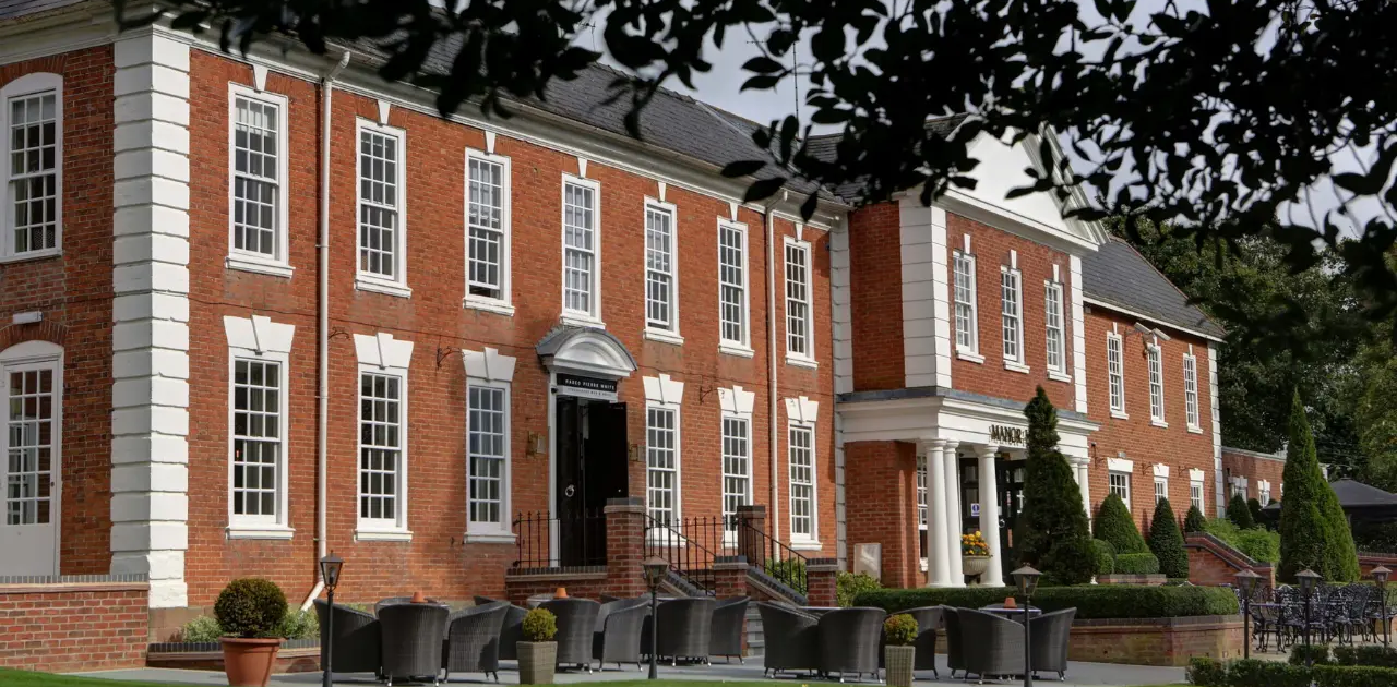 A beautiful manor house with a brick facade and a landscaped garden, perfect for hosting weddings in Birmingham.