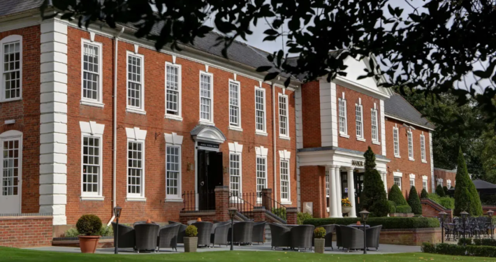 A beautiful manor house with a brick facade and a landscaped garden, perfect for hosting weddings in Birmingham.