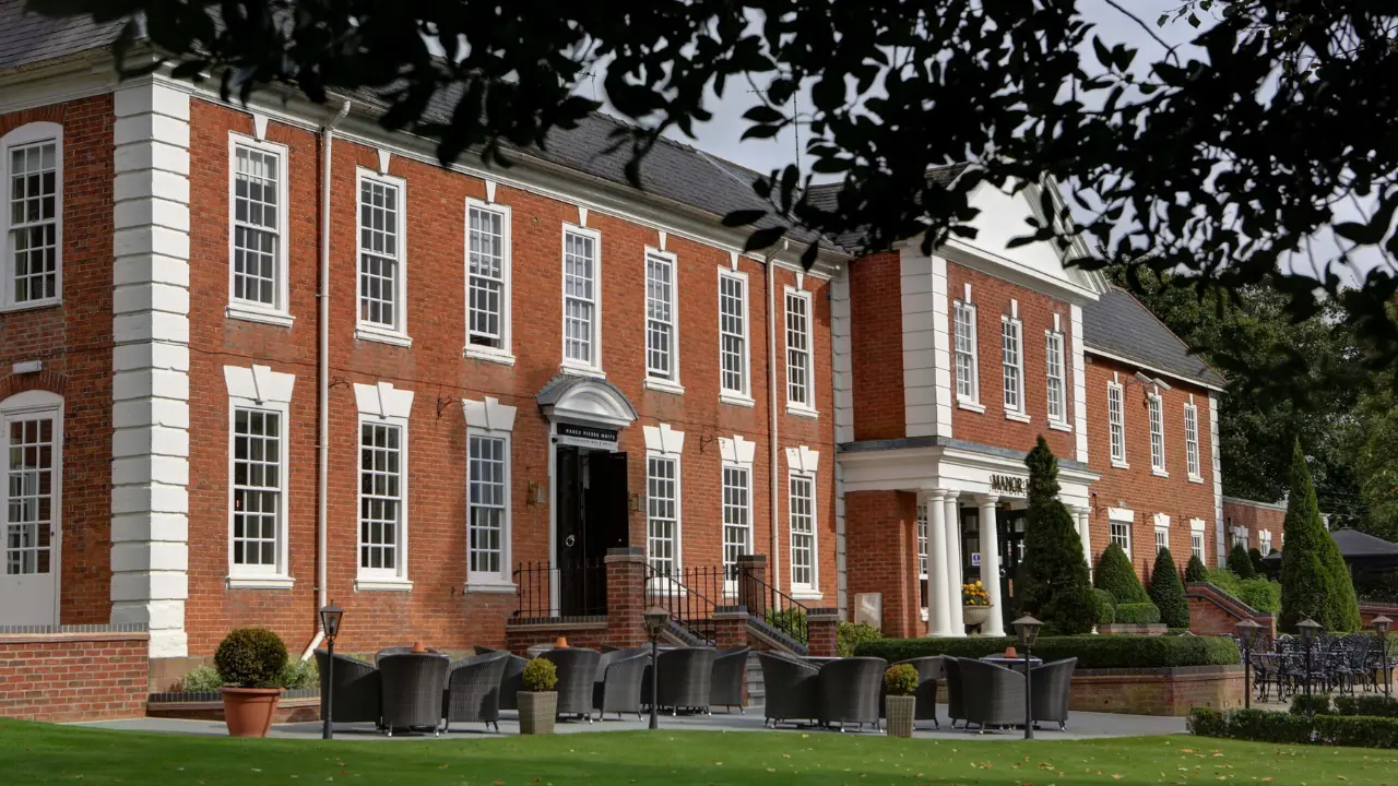 A beautiful manor house with a brick facade and a landscaped garden, perfect for hosting weddings in Birmingham.