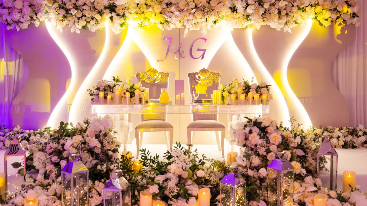 A unique and stylish head table with personalized initials, floral arrangements, and a modern backdrop. This image highlights the contemporary wedding decor at the National Motorcycle Museum.