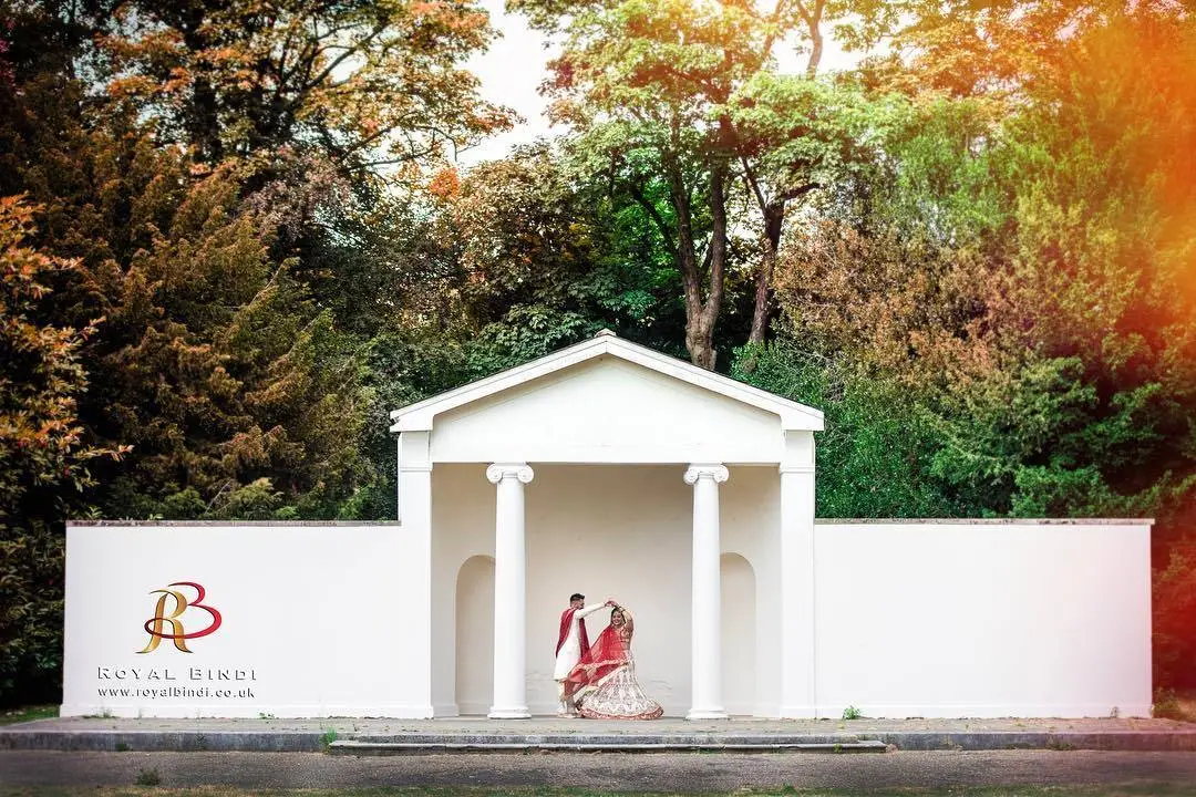 A beautiful Gujarati couple posed against a serene white backdrop, captured during their wedding photoshoot.