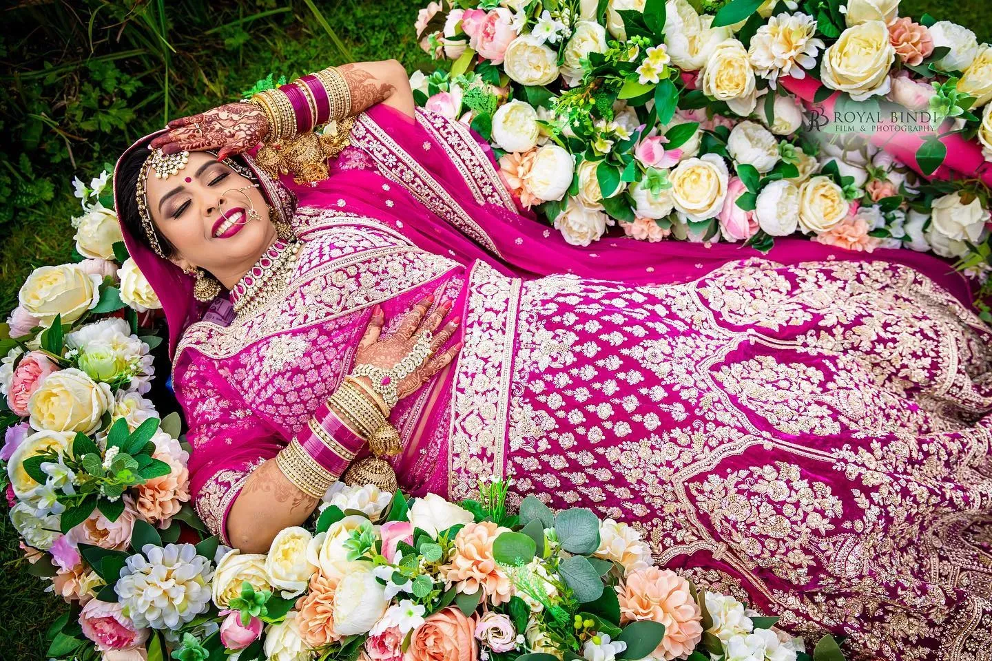 A radiant bride surrounded by flowers during a Hindu wedding photoshoot.