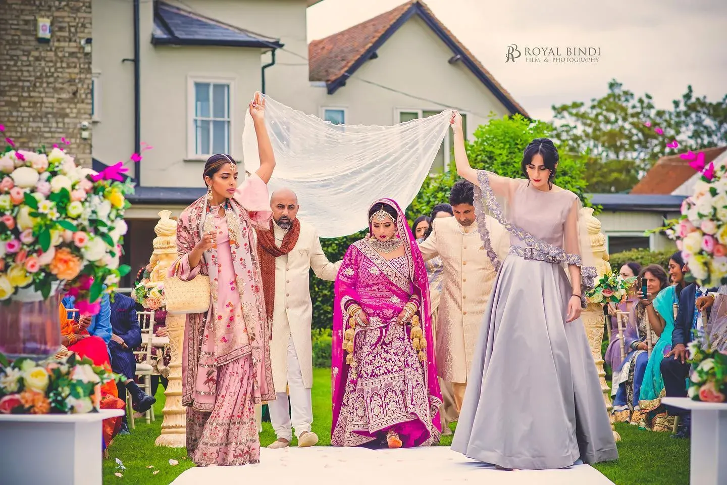 A vibrant Hindu wedding featuring the bride in a pink lehenga, captured during the celebration.