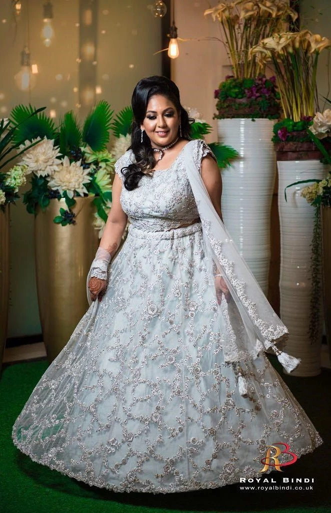 Radiant bride in a detailed gown, captured during a lively Gujarati wedding photoshoot.